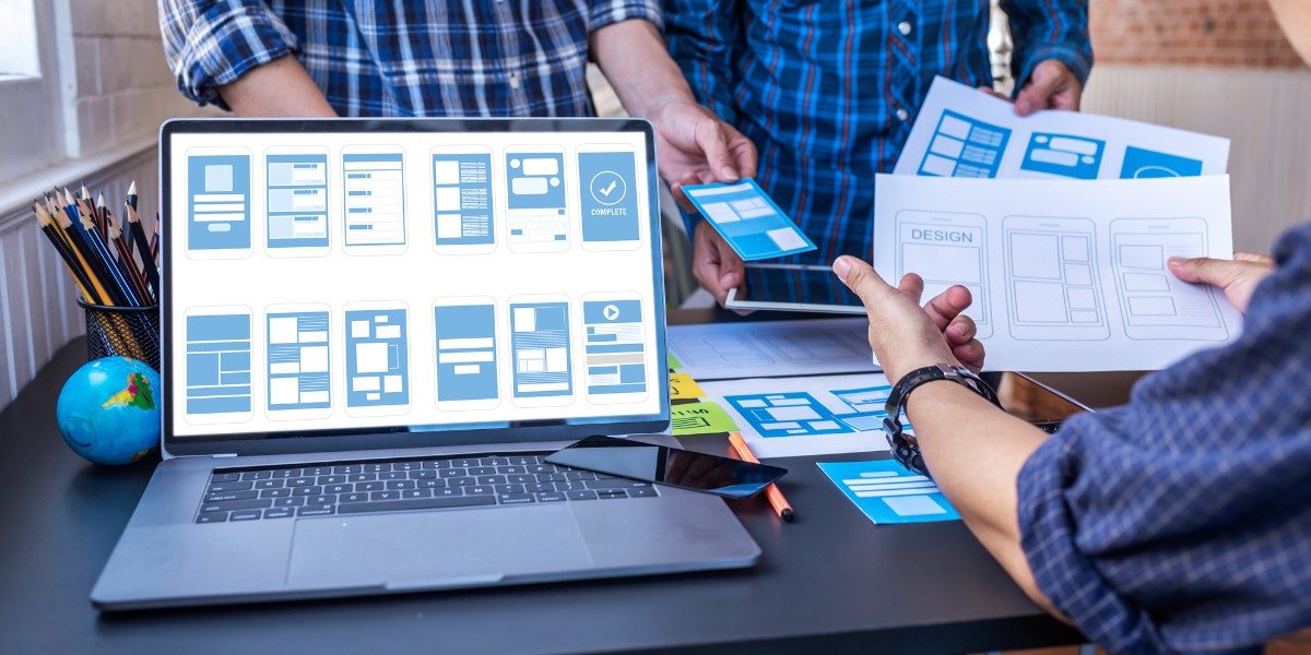 A group of people reviewing paper and digital mockups of user interface designs