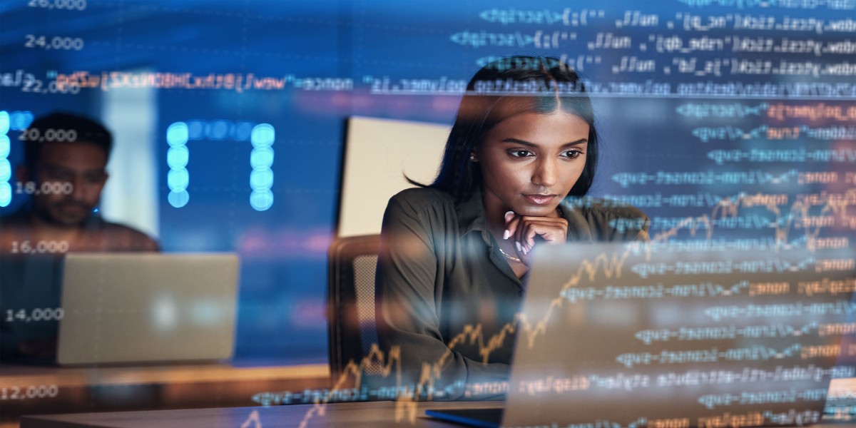 A transparent image of software code layered over a person working at a laptop
