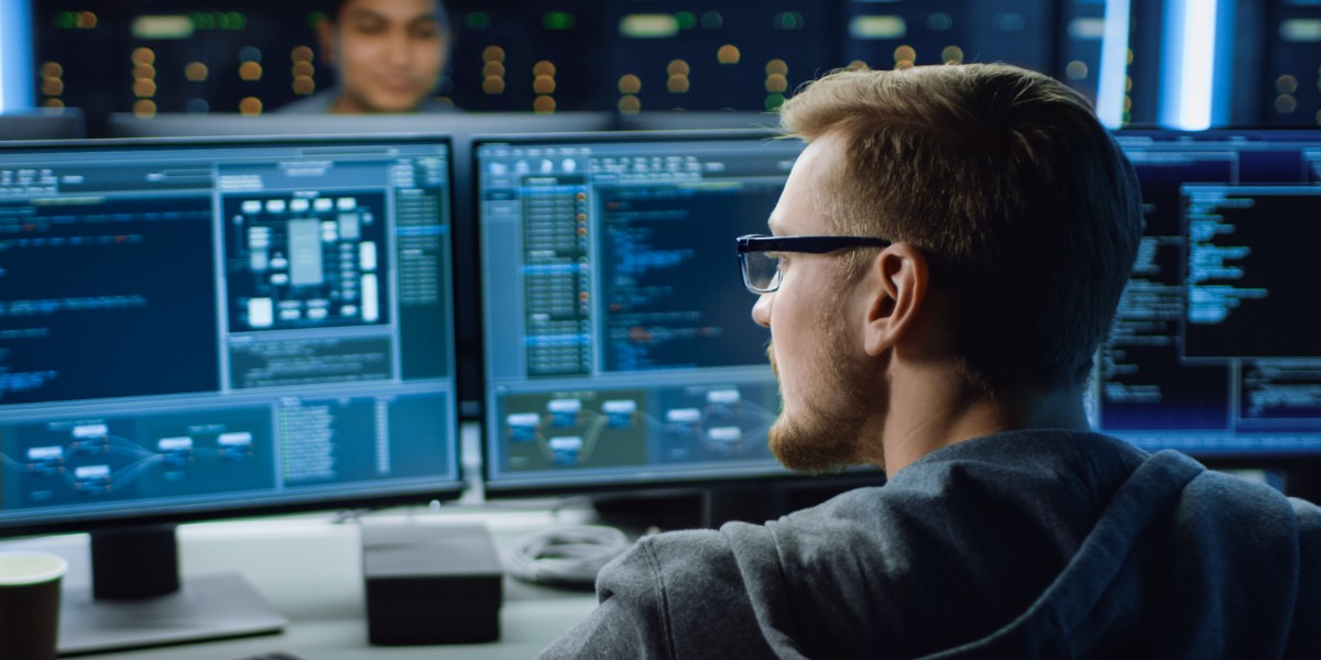 Person working in front of multiple computer monitors