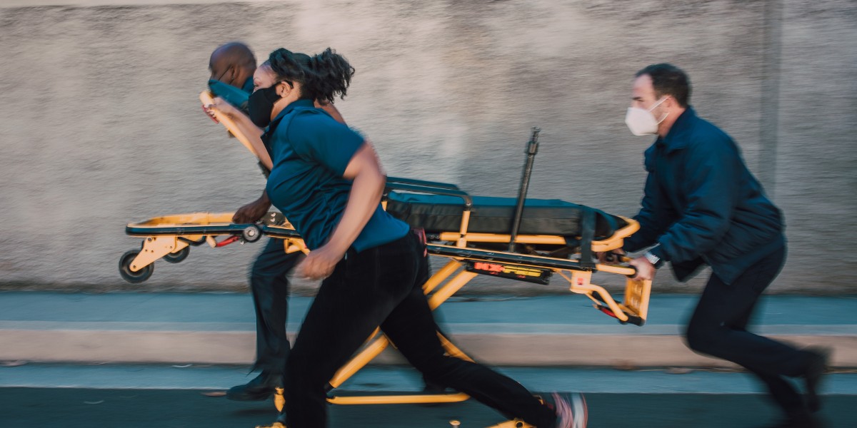 A group of medical professionals running with a gurney