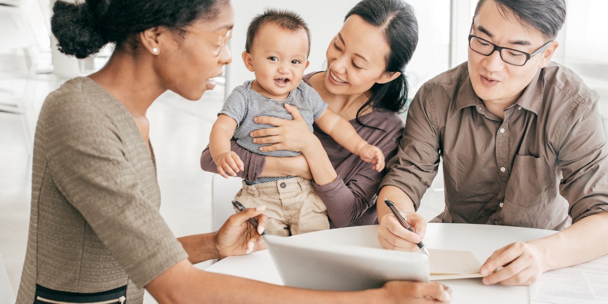 An insurance agent signing paperwork with a family of three